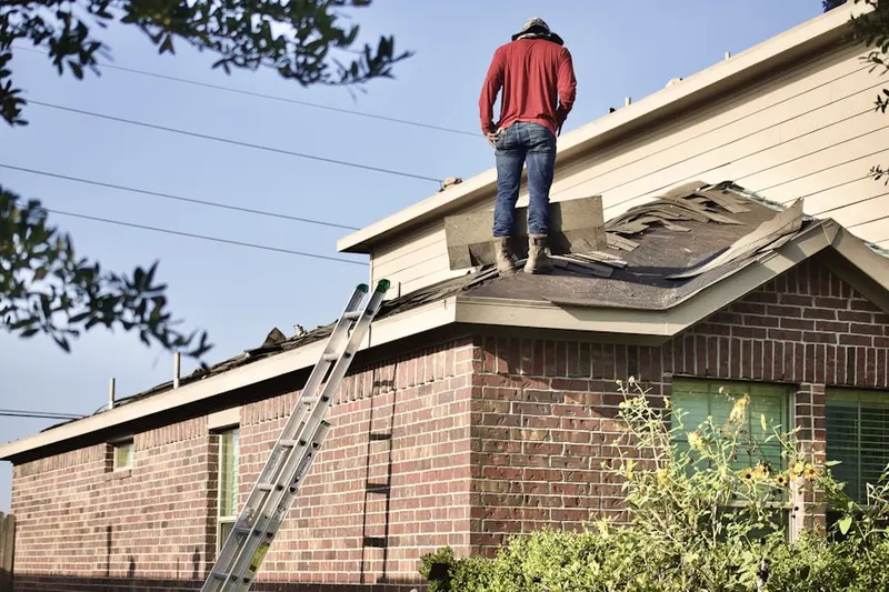 Professional roofer working on a residential roof in Winchendon